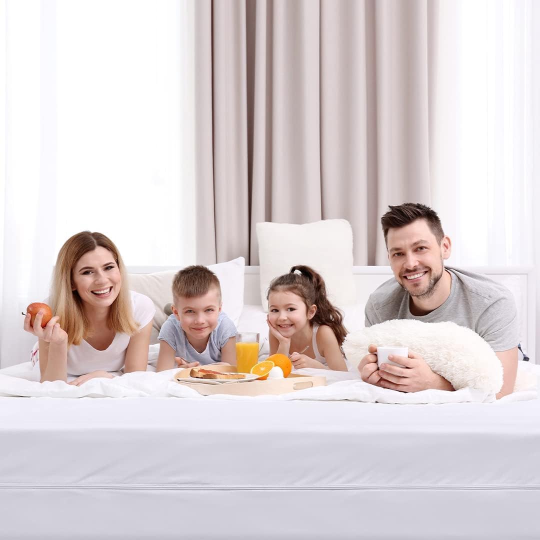 Smiling family enjoying breakfast in bed together on bright morning.
